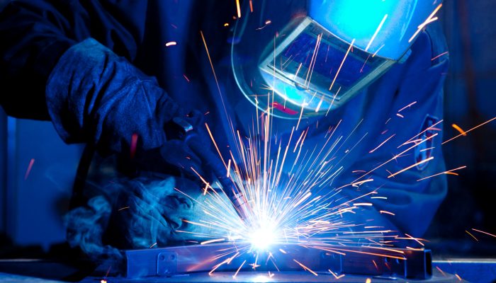 Welder erecting technical steel. Industrial steel welder in factory technical